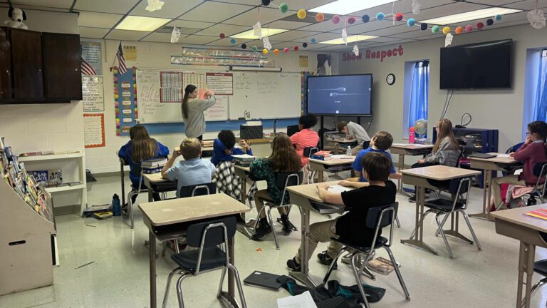 Students listening to teacher in Christian school classroom