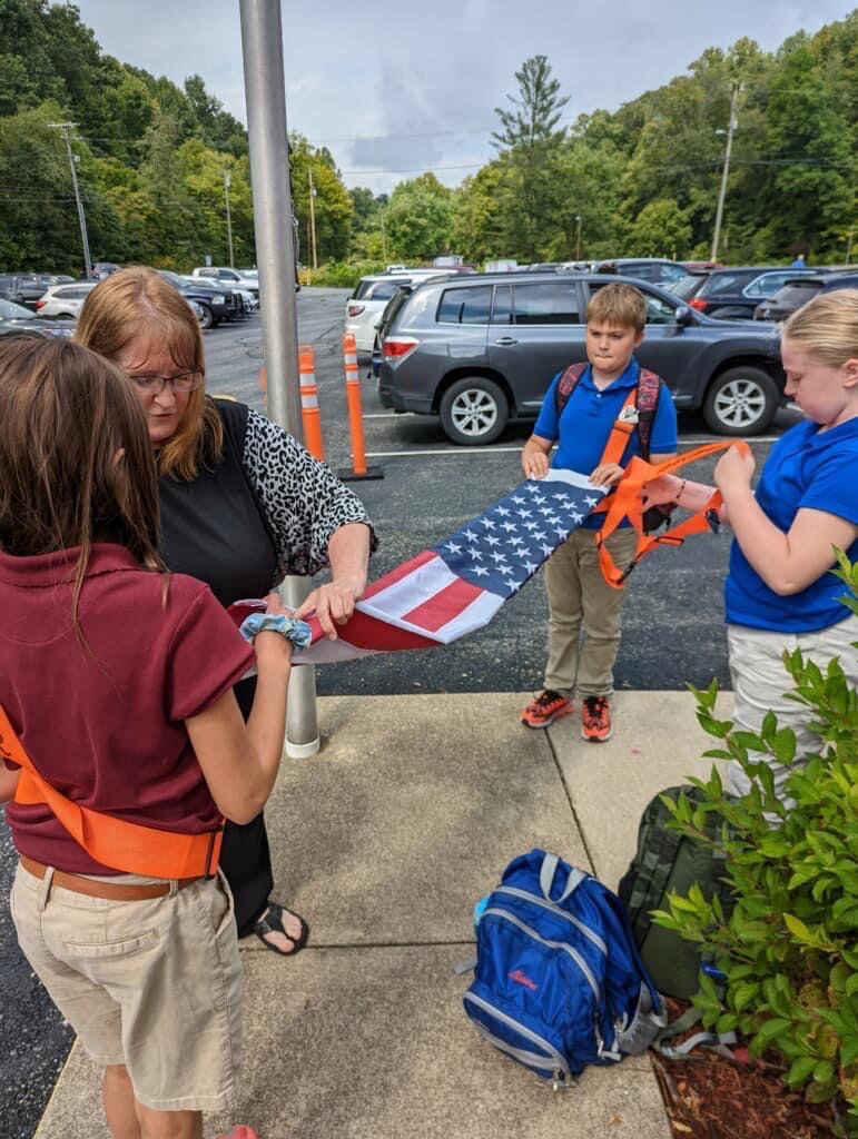 students folding American flag at school