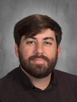 Headshot of David Bush, wearing a dark sweater and sporting a beard.