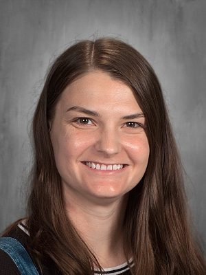 Kelli Ferguson, smiling headshot with long brown hair.