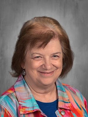 Portrait of Valerie Kemper smiling, wearing a colorful jacket.