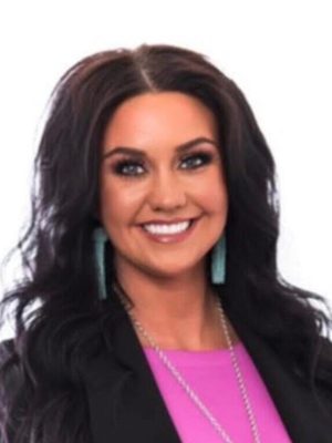 Jessica Adkins portrait, smiling with dark hair and turquoise earrings.