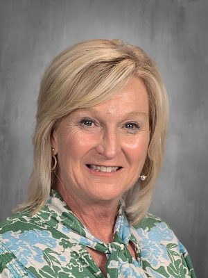 Headshot of Gina Bush, smiling with blonde hair and wearing a floral blouse.